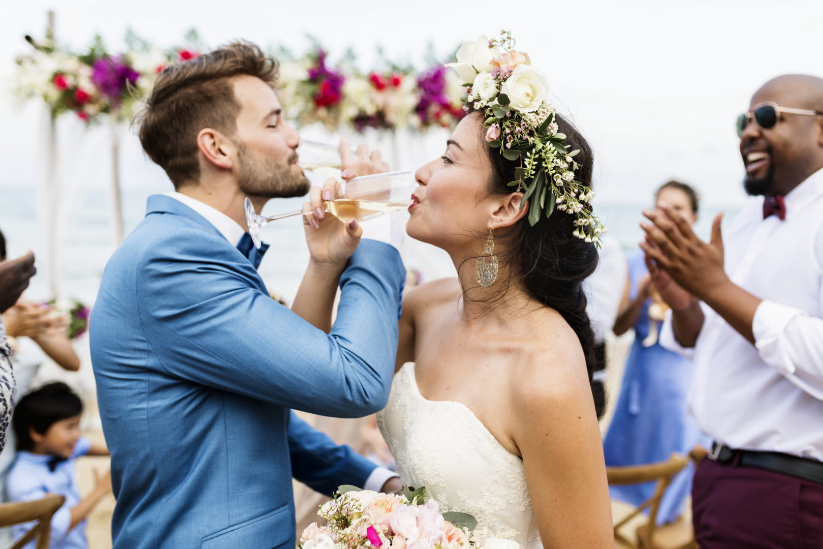 Cheerful newlyweds at beach wedding ceremnoy