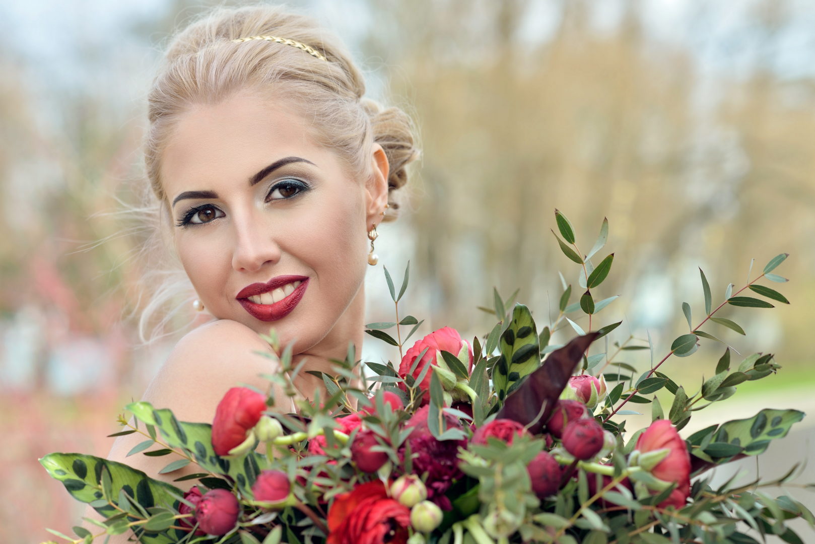 Beauty bride in bridal gown with bouquet and lace veil on the nature. Beautiful model girl in a white wedding dress. Female portrait in the park. Woman with hairstyle. Cute lady outdoors